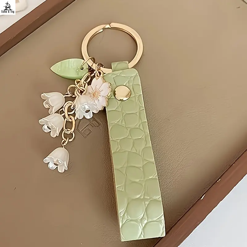 E&I    Elegant Pastel Green PU Leather Keychain with Lily of the Valley Charms - A Stylish Floral Ring for Keys, Perfect for Valentine's Day and New Year. Also a Great Car and Bag Accessory